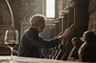 Norman craftsman studying the junction of half-timbered wood and Savoyard stone inside a farmhouse, with soft morning light and an intimate, immersive feel.